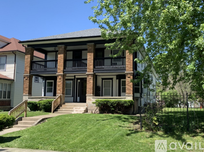 A house with a balcony and a front door is for sale.