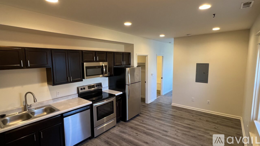 A kitchen with dark wood cabinets and stainless steel appliances.