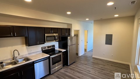 A kitchen with dark wood cabinets and stainless steel appliances.