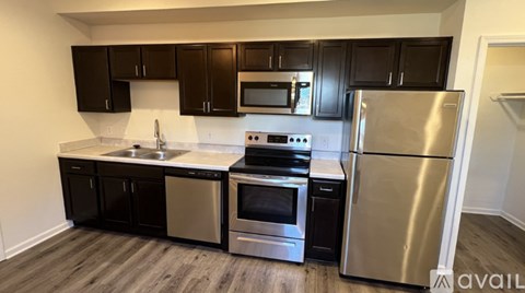 A kitchen with black cabinets and stainless steel appliances.