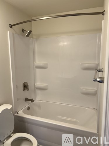 A white bathroom with a toilet and a bathtub.