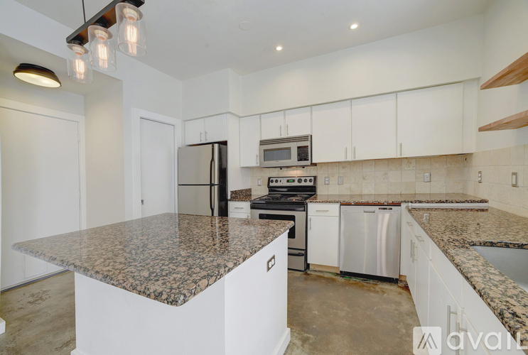 A kitchen with granite countertops and white cabinets.