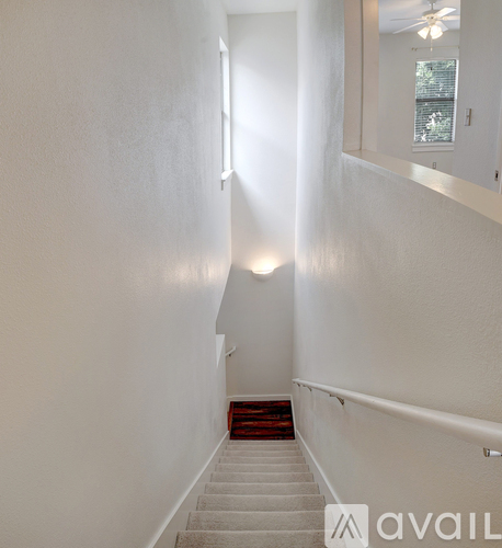 A staircase with a red carpeted landing.