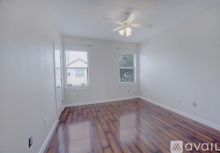 A room with a wooden floor and a ceiling fan.