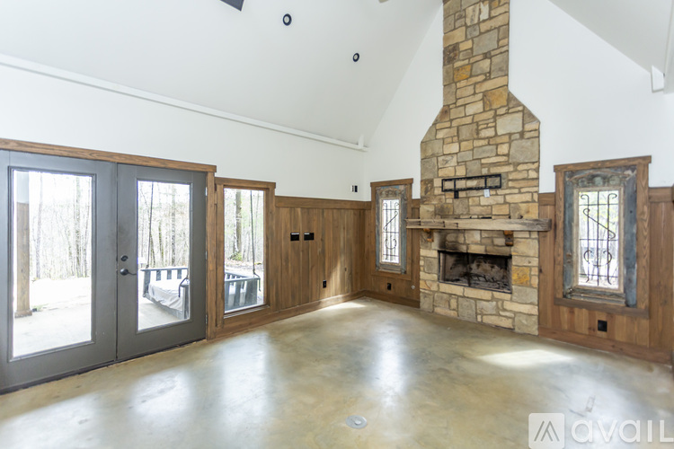 A spacious living room with a stone fireplace and wooden accents.