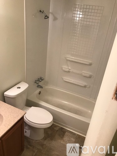 A white toilet sits next to a bathtub in a bathroom.