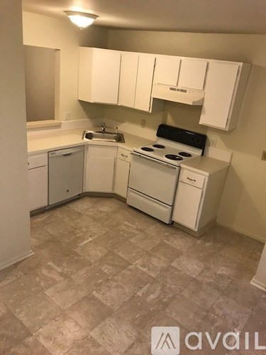 A kitchen with white cabinets and appliances.