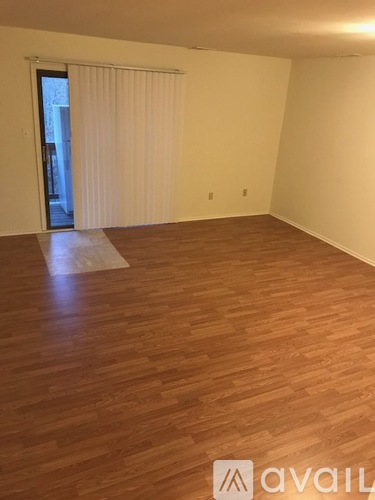 A room with wooden flooring and a sliding door.