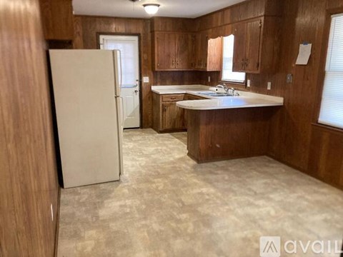 A kitchen with wooden cabinets and a white fridge.