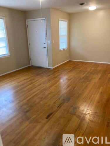 A room with wooden flooring and a white door.