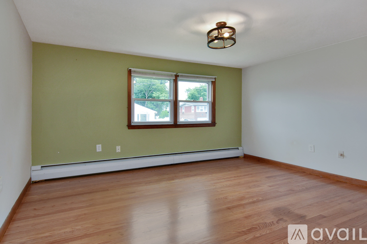 A room with a window and wooden flooring.