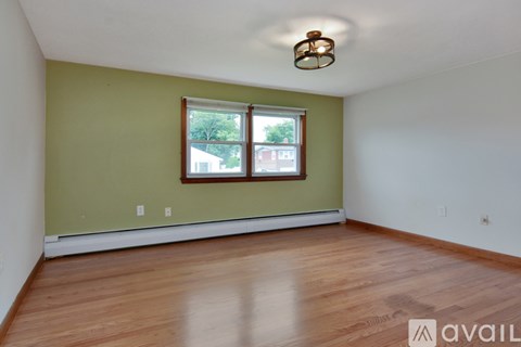 A room with a window and wooden flooring.