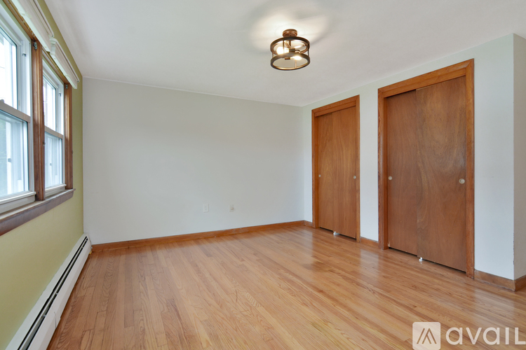 A room with wooden floors and two doors.