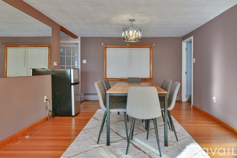 A dining room with a table and chairs.
