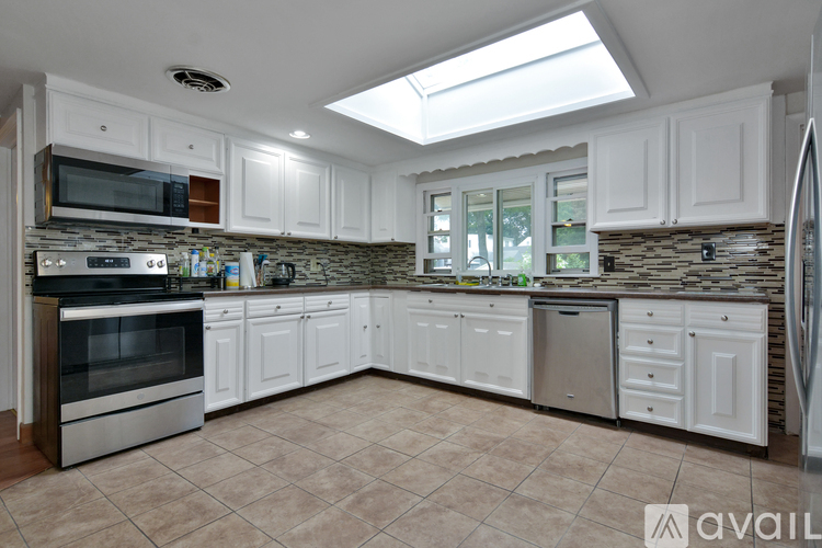 A kitchen with white cabinets and a tile backsplash.