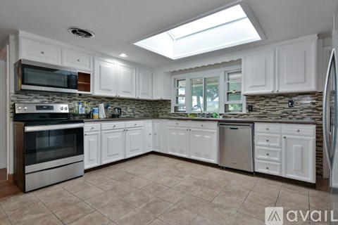 A kitchen with white cabinets and a tile backsplash.