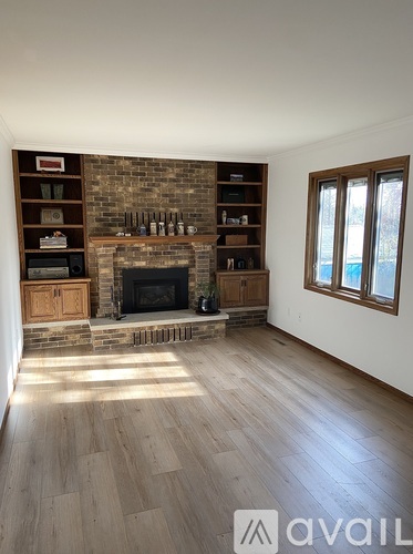 A living room with a fireplace and wooden floors.