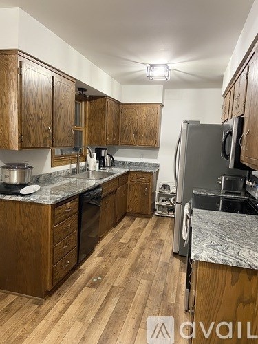 A kitchen with wooden cabinets and a granite countertop.