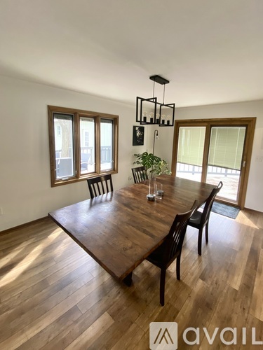 A dining room with a wooden table and chairs.