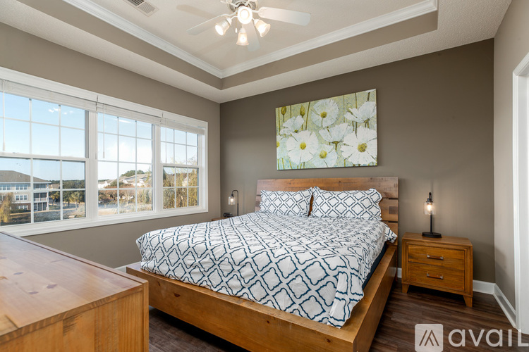 A bedroom with a large bed and a painting of flowers on the wall.
