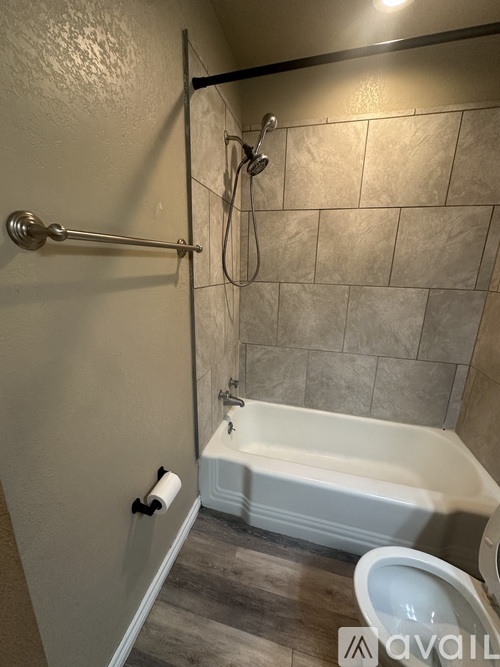A bathroom with a toilet, tub, and shower.