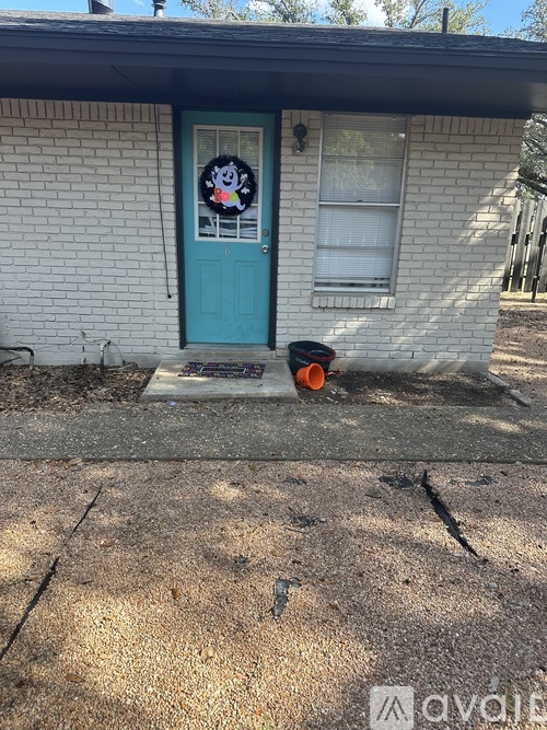 A small house with a blue door and a wreath on it.