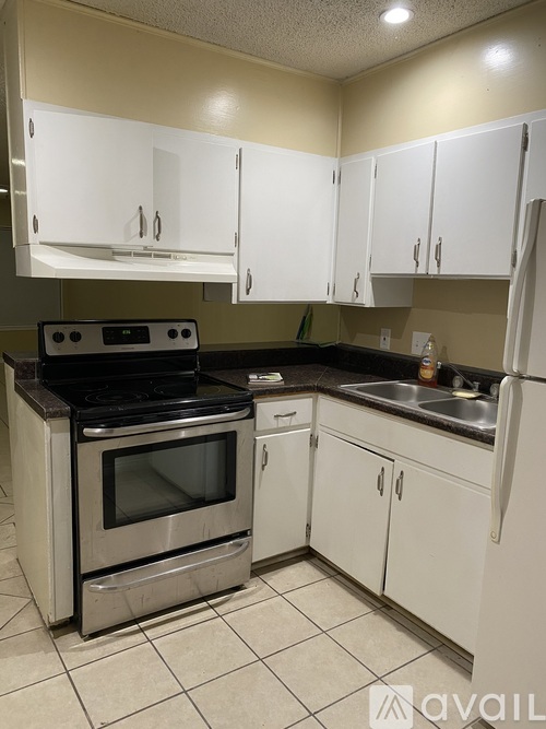 A kitchen with white cabinets and a black stove top oven.