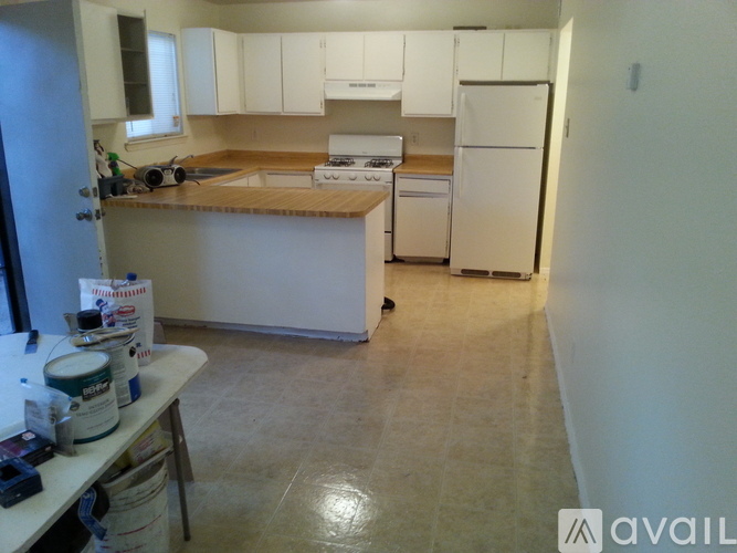 A kitchen with white appliances and cabinets is available for rent.