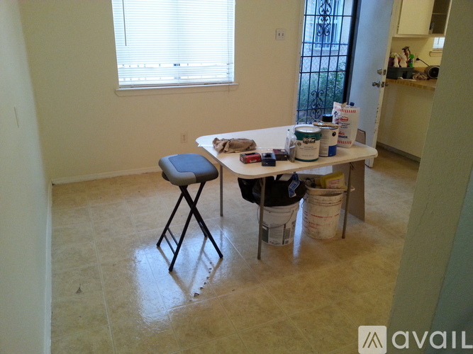 A room with a table and a stool in it.