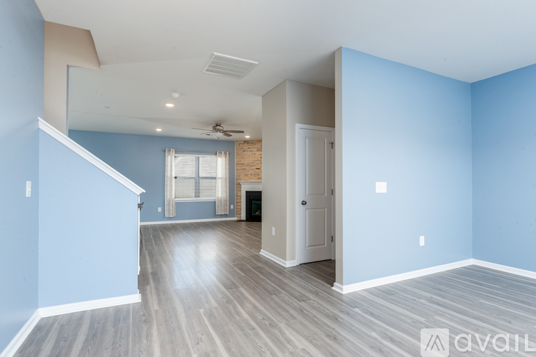 A spacious room with blue walls and wooden flooring.