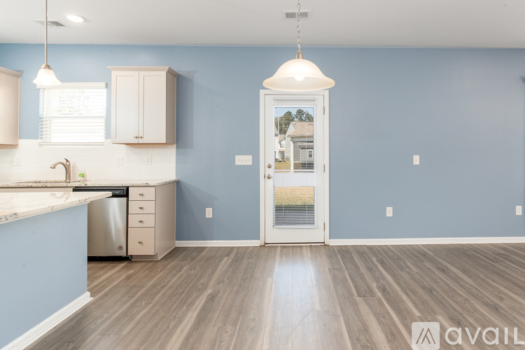 A kitchen with blue walls and wooden floors.