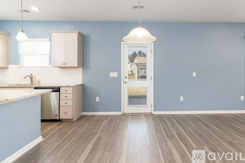 A kitchen with blue walls and wooden floors.