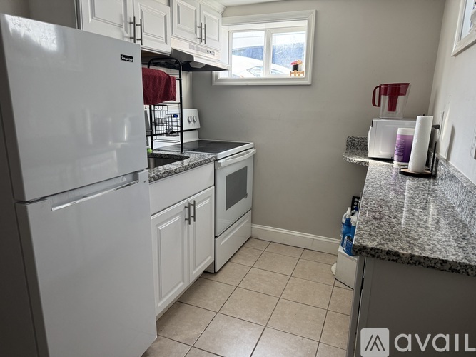 A kitchen with white appliances and cabinets.