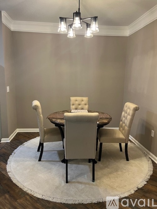 A dining room with a round table and chairs.