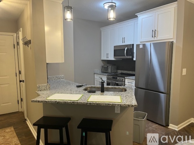 A kitchen with a granite countertop and stainless steel appliances.