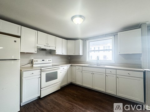 A kitchen with white appliances and cabinets.