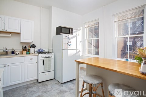 A kitchen with white cabinets and a white fridge.