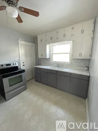 A kitchen with a stove, oven, and a fan.