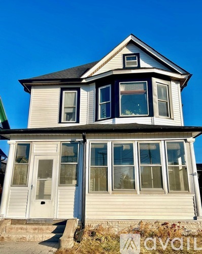 A two-story house with a white exterior and a black roof.