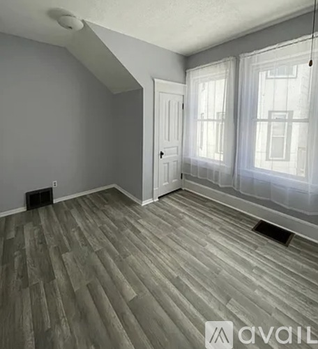 A room with a grey floor and a white door.