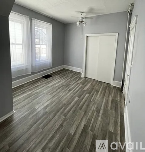 A room with wooden flooring and a ceiling fan.