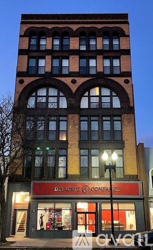 A Delacroix Companies building with a red awning and lit windows.