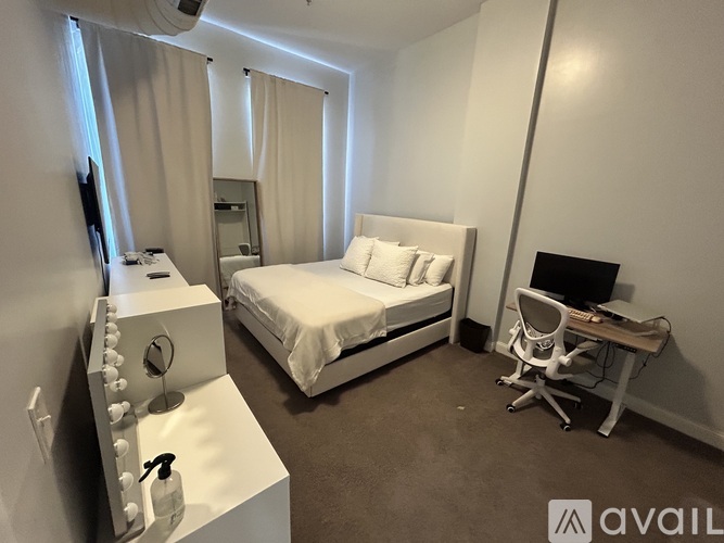 A bedroom with a bed, desk, and chair.