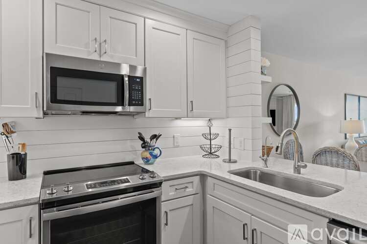 A modern kitchen with a stainless steel oven and white cabinets.