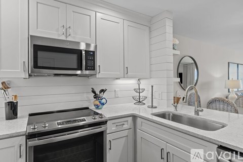 A modern kitchen with a stainless steel oven and white cabinets.
