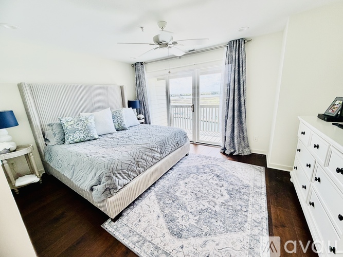 A bedroom with a large bed and a ceiling fan.