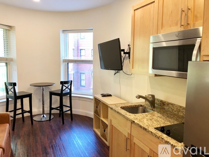 A kitchen with a table and chairs by a window.