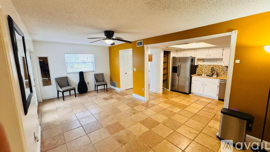 A living room with a tiled floor and a ceiling fan.
