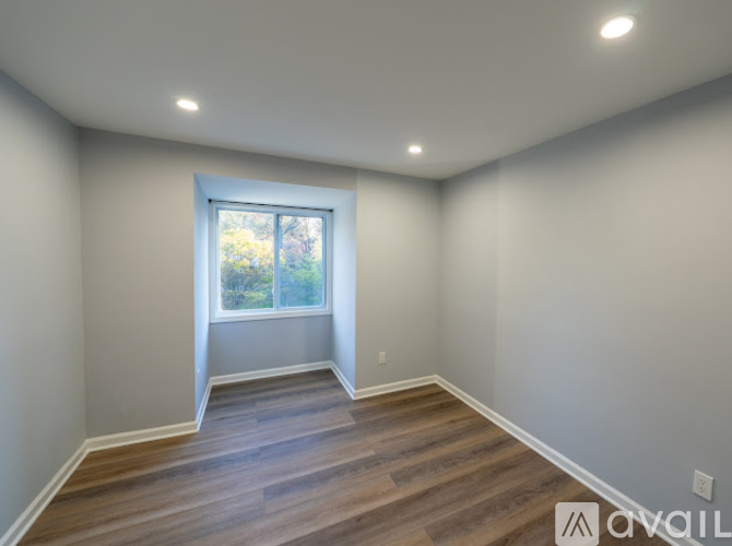 A room with a window and wooden flooring.