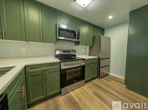 A kitchen with green cabinets and a stove top oven.